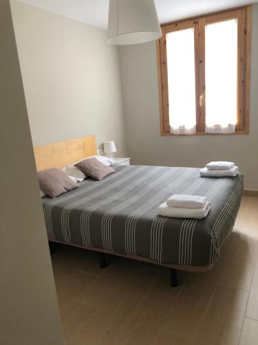 a bedroom with a bed with two towels on it at Apartamento Casa Francho in Panticosa