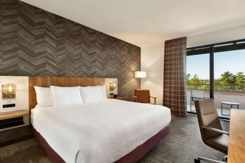 a hotel room with a bed and a balcony at La Quinta Inn & Suites by Wyndham Santa Rosa Sonoma in Santa Rosa