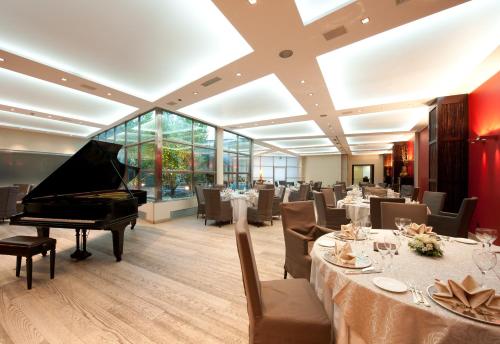 a restaurant with a piano and tables and chairs at Italiana Hotels Cosenza in Cosenza