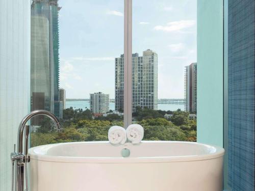 a white toilet sitting in front of a large window at Novotel Miami Brickell in Miami