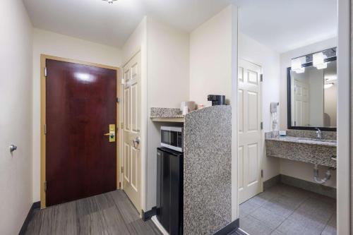 a small kitchen with a door and a sink at Quality Inn & Suites Huntsville Research Park Area in Huntsville