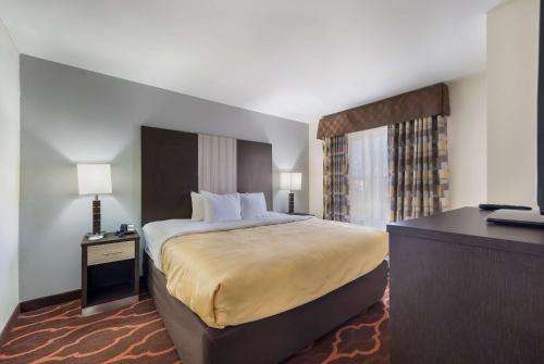 a hotel room with a large bed and a desk at Quality Inn & Suites Huntsville Research Park Area in Huntsville