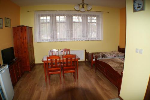 1 dormitorio con mesa, sillas y 1 cama en Apartament Jozefina, en Szklarska Poręba