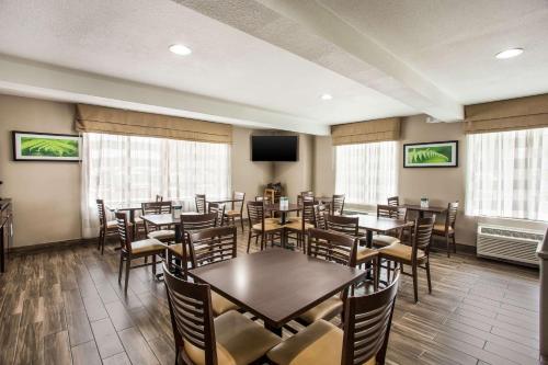 a dining room with tables and chairs and a flat screen tv at Sleep Inn Kansas City International Airport in Kansas City