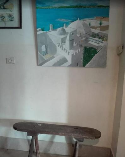 a bench in a room with a picture on the wall at le mirador in Hammamet