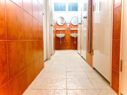 a corridor of a bathroom with two sinks and mirrors at Pillow & Bread in Bangkok
