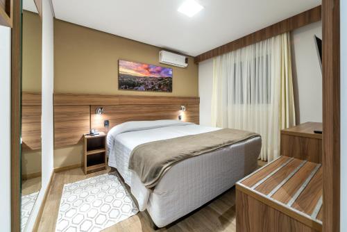 a bedroom with a large bed in a room at Hotel Fioreze Centro in Gramado