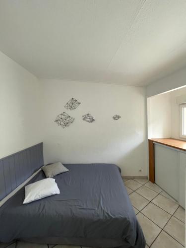 - une chambre avec un lit orné de dessins sur le mur dans l'établissement Villa dans les dunes, à Torreilles