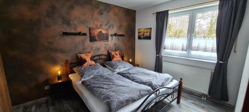 a bedroom with a bed with blue sheets and a window at Ferienwohnung Aaron III inkl Bettwäsche Handtücher Endreinigung in Hahnenklee-Bockswiese