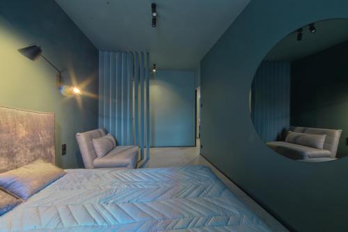 ジブヌベクにあるBlue Baltic Apartmentのベッドルーム1室(ベッド1台、円形鏡付)