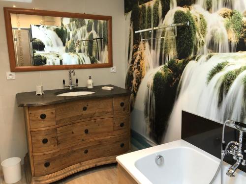 a bathroom with a wooden sink and a mirror at Les voiles rouges in Saint-Martin-de-Ré