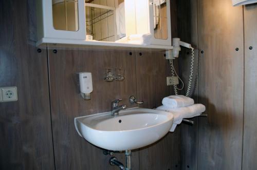 W łazience znajduje się umywalka, lustro i ręczniki. w obiekcie Leipziger Hotel w Lipsku