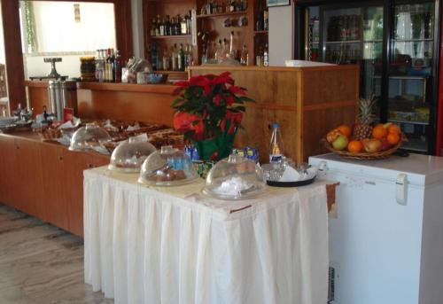 a table with a white table cloth and fruit on it at Oscar Hotel Lefkada in Nydri