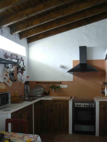 a kitchen with wooden cabinets and a stove top oven at Casa da Tia Maria By Alojamentos Vitinho in São Luis