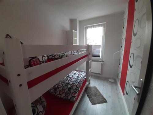 a small room with two bunk beds and a window at Ferienwohnung John in Eisenach