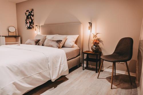 ein Schlafzimmer mit einem Bett und einem Stuhl darin in der Unterkunft THE LOFT LODGE - ATELIER in Braunschweig