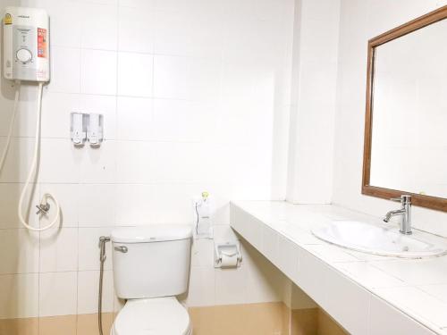 a white bathroom with a toilet and a sink at Phurua Bussaba Resort & Spa in Loei