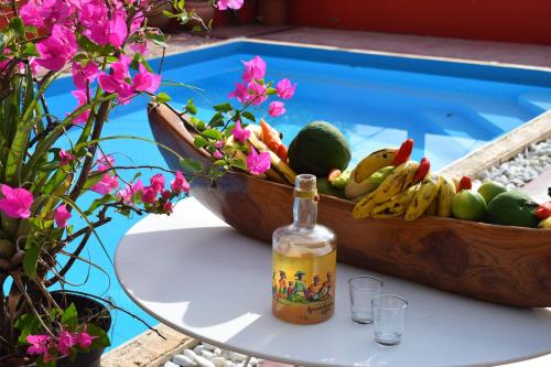 una bottiglia di vino seduta su un tavolo accanto a un cesto di frutta di Les gîtes de Bunel a Les Abymes