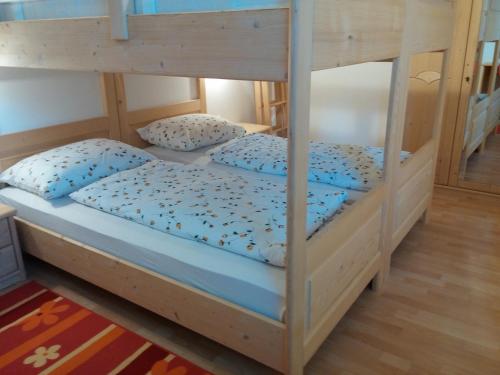 a bunk bed with blue sheets and pillows on it at Ferienwohnung Winklerhof in Lana