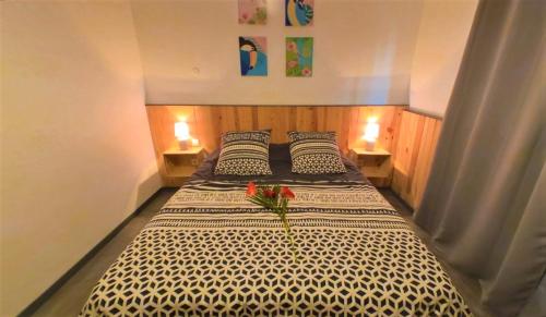 un grande letto con due cuscini e fiori sopra di Les gîtes de Bunel a Les Abymes