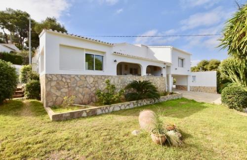 a white house with a stone wall at VILLA " VISTA JAVEA "- Home away from home in Jávea