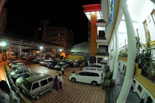 a group of cars parked in a parking lot at night at Kediyoor Hotels in Udupi