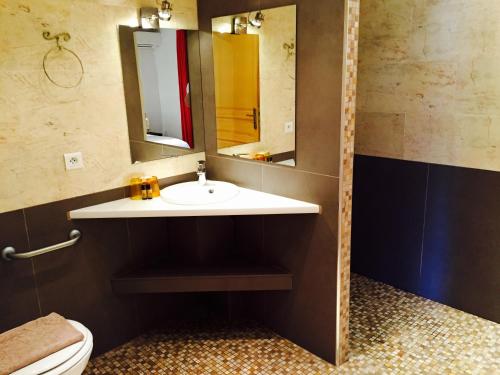 a bathroom with a sink and a mirror and a toilet at Hôtel Beau Soleil in Le Lavandou