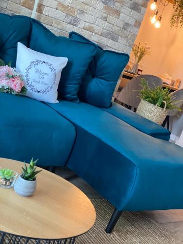 a blue couch in a living room with a table at Sarah Home in Hunedoara