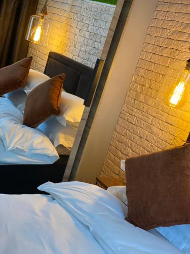 two beds sitting next to a brick wall at Sarah Home in Hunedoara