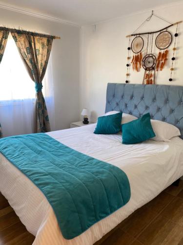 a bedroom with a large bed with a blue headboard at Cabañas Licanantay in Vallenar