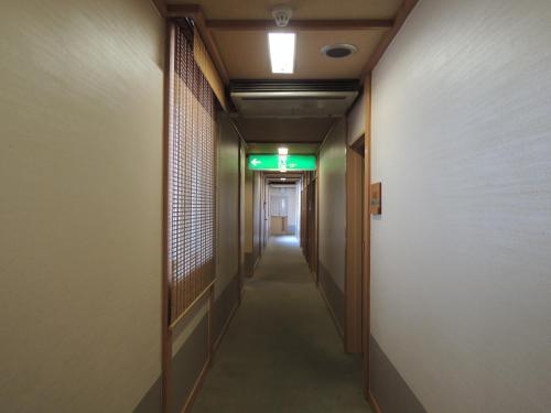a hallway of an office building with a light on the ceiling at Ryokan Kousen Kazeya Group in Nara