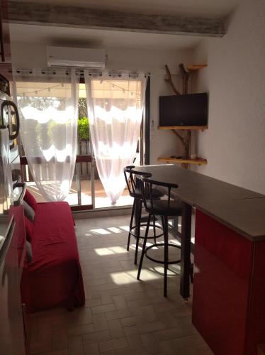 une cuisine avec une table et des chaises et une télévision dans l'établissement Résidence le Neptuna 50 mètres plage réservation du samedi au samedi en haute saison, au Cap d'Agde