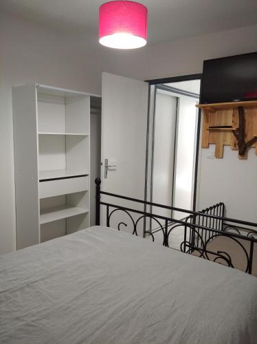 - une chambre avec un lit et une lumière rose dans l'établissement Résidence le Neptuna 50 mètres plage réservation du samedi au samedi en haute saison, au Cap d'Agde