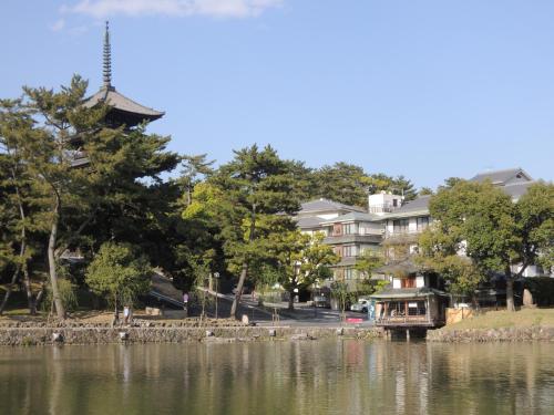 a large building next to a body of water at Ryokan Kousen Kazeya Group in Nara