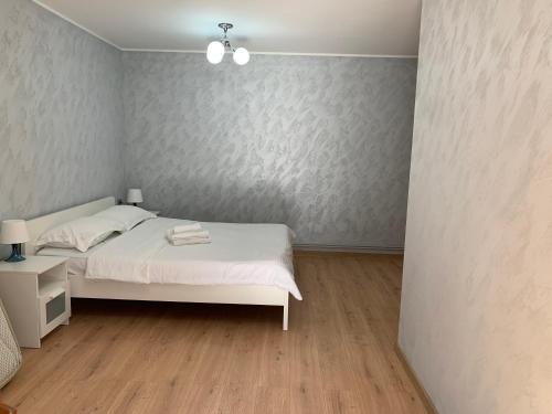 1 dormitorio con cama blanca y pared en Casa The Grey House Caciulata/Calimanesti, en Căciulata
