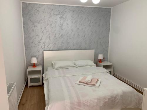 un dormitorio con una cama blanca con sombrero en Casa The Grey House Caciulata/Calimanesti, en Căciulata