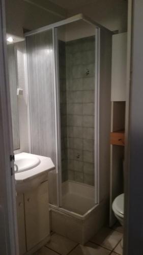 une salle de bain avec une douche, un lavabo et des toilettes dans l'établissement SUN, à Portiragnes
