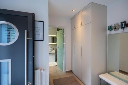 a hallway with white cabinets and a green door at RockLoft Oldenburg in Oldenburg