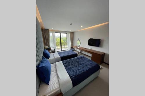 a hotel room with two beds and a television at M Beach Luxury Villas Phu Quoc in Phu Quoc