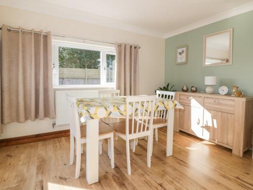 a dining room with a table and chairs and a window at Lower Brambleside in Truro