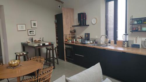 eine Küche mit einem Tisch und einer Theke sowie einem Tisch und Stühlen in der Unterkunft Domaine Sesquier Mas d'exception Pivoine in Mèze