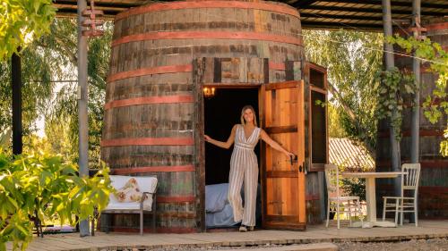 a woman standing in front of a wooden boat at Cava Colchagua Hotel Boutique in Santa Cruz