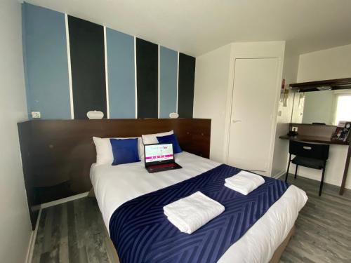 a bedroom with a bed with a laptop on it at Fasthotel Tours Nord in Parçay-Meslay