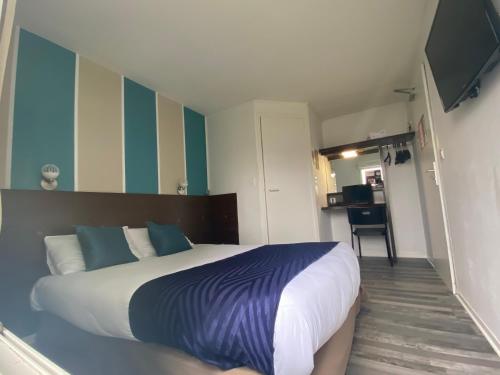 a bedroom with a large bed and a flat screen tv at Fasthotel Tours Nord in Parçay-Meslay