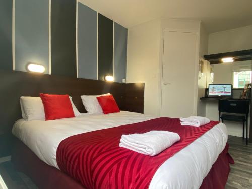 a bedroom with a large bed with red and white pillows at Fasthotel Tours Nord in Parçay-Meslay