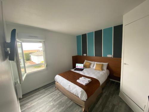a small bedroom with a bed with a laptop on it at Fasthotel Tours Nord in Parçay-Meslay