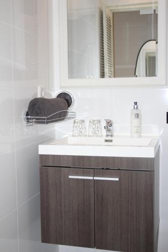 a bathroom with a sink and a mirror at Slapen & Smullen in Swalmen