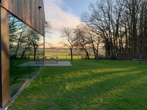 a view of a park with a bench in the grass at Woodhouse94 in Zonnebeke