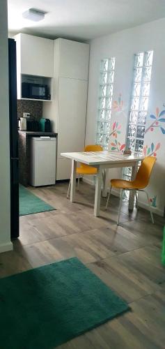 a dining room with a white table and yellow chairs at Nordapartament in Suceava