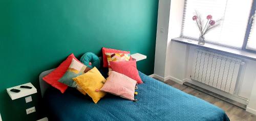 a bedroom with a blue bed with colorful pillows at Nordapartament in Suceava
